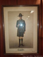 Full view of framed print depicting a WWII era uniformed figure standing in riding attire with a crop.