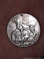 Front side of the WWII medal showing a lion standing on a defeated German eagle with dates 1939-1945 above