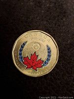 Reverse side of the 2020 Canadian one dollar coin with colored maple leaf and commemorative inscriptions