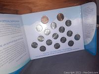 Multiple 2010 Vancouver Olympics commemorative coins arranged in original blue and white holder with information about the coin collection.