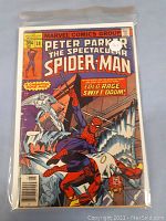 Front cover of Peter Parker The Spectacular Spider-Man comic issue #18 sealed in a plastic sleeve, showing classic comic book cover art and title.