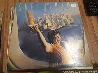 Photo of Supertramp vinyl record album cover featuring distinct illustrated artwork of man holding breakfast tray and abstract cityscape background.