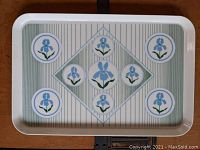 Full view of rectangular melamine serving tray with blue iris flowers and striped background.
