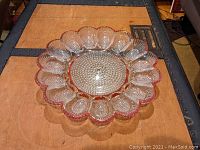Top-down view of the ruby flashed deviled egg serving platter showing scalloped edge and multiple egg sections.