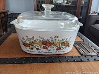 Front view of Corning Ware Spice of Life 5 liter casserole dish with colorful vegetable design and clear glass lid