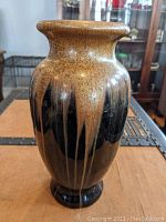 Front view of the vase showing the speckled brown glaze and drip effect with black base.