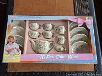Photo of the complete 16-piece Fishel porcelain child's tea set in original pink and blue box featuring a child on the packaging.