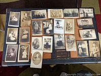 Overview of all 23 antique postcards laid out showing varied subjects including portraits and thematic imagery.