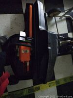 Top-down view of entire chainsaw in black plastic tub