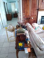 Tabletop shot showing model ship, decorative boxes, plush bear, sailor figurine, desk clock, artwork, binoculars and red sculpture