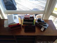 Top-down view of a table displaying the keyboard, filing cases, stapler, tape dispenser, wooden organizer and envelopes.