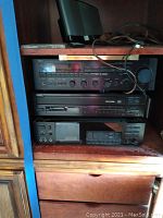 Three stacked Yamaha components (receiver at top, CD player middle, cassette deck bottom) in wooden cabinet