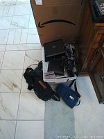 Top view showing the full lot arranged in a box with cords, battery packs, and multiple cases on the floor beside it.