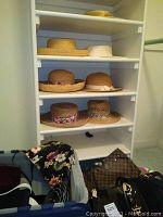 Closet shelving displaying seven straw hats across four shelves