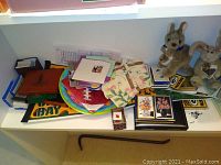 Shelf with stuffed animal rabbits, assorted napkins, paper goods, and framed card displays.