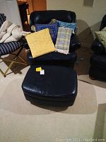 Blue leather armchair with cushions and matching blue leather ottoman in front.