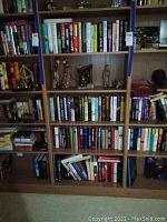 Full bookshelf displaying rows of hardback books with some decorative figurines in center section