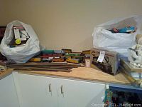 Overview of train cars, boxed locomotive and track sections on countertop