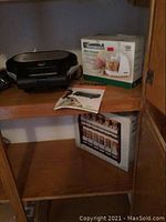 Kenmore Mini Chopper with box and user manual, Wolfgang Puck Pie and Pastry Baker, boxed spice rack visible on wooden shelves