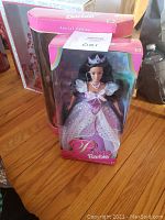 Front and angled views of Princess Barbie in purple gown with tiara and Target 35th Anniversary Barbie in red gown, both still in original display boxes.