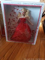 Holiday Barbie 2012 doll in original box with red strapless gown and silver necklace, box decorated with holiday motifs.