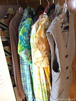 Hanging vintage dresses and pant suit showing patterns and styles