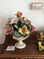 Front view of the porcelain flower arrangement showing variety of colorful flowers.