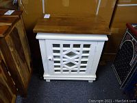 Front view of wood cabinet showing white lattice door with glass insert and natural wood top.