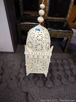 Front angle view of white Moroccan iron lantern with hand-cut decorative patterns on dome and sides.
