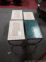 Four ceramic tile tables: three nesting with beige and white tiles, one extra blue ceramic tile table with visible surface chips.