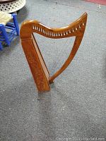 Full view of harp showing curved neck, strings, and carved side panel
