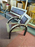 Photo showing both the Moroccan couch and chair angled in the room, highlighting the leather seats and metal-overlay wood frame with visible brads.