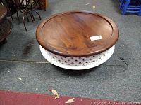 Full view of the round Moroccan tea table showing the white lattice base and solid wood top.