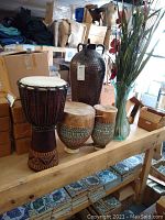 Overview of all items including wooden djembe, terracotta bongos, metal floor vase, glass vase with florals