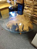 Overhead view showing round glass top and teak root base