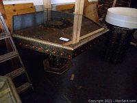 Full view of the hexagonal Moroccan table with glass top and metal overlay detailing.