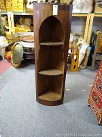 Full view of the Moroccan-style wooden corner shelf unit showing three shelves and arched design