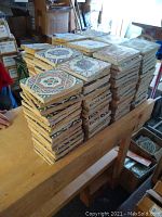 Stacks of over 250 square cement tiles 6x6 with various traditional Moroccan geometric patterns in multiple color schemes.