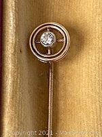 Straight-on view of circular head showing bezel-set diamond and concentric circle motif