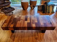 Front perspective of coffee table showing block-pattern rosewood top and black legs