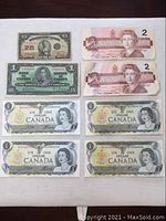 Overview of all Canadian banknotes in lot including 1923 25 cent note, 1937 one dollar note, 1973 one dollar notes including two with hole punched, and 1986 two dollar notes.