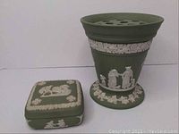 Photo of sage green jasperware flower vase and square trinket box on white background showing white classical relief decorations and floral garlands.
