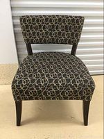 Front view of the accent chair showing interlocking circle upholstery pattern and wooden legs