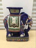 Front view of ceramic elephant stand showing saddle cloth design