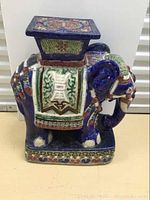 Front view of ceramic elephant stand showing saddle blanket design and base decoration