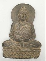 Full front view of seated Buddha statue showing entire figure and base
