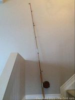Full assembled 6-section rod with mounted reel leaning against wall