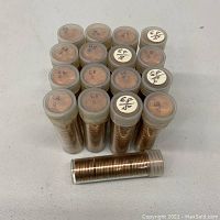 Seventeen plastic tubes filled with rolled 1968 S Lincoln Cent pennies stacked in a pyramid formation showing the tube tops.