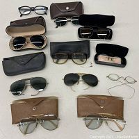Overview of all eyeglasses and aviator sunglasses laid out with cases