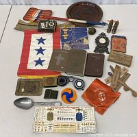 Overview of lot on white table showing flag, books, trays, pins and other memorabilia